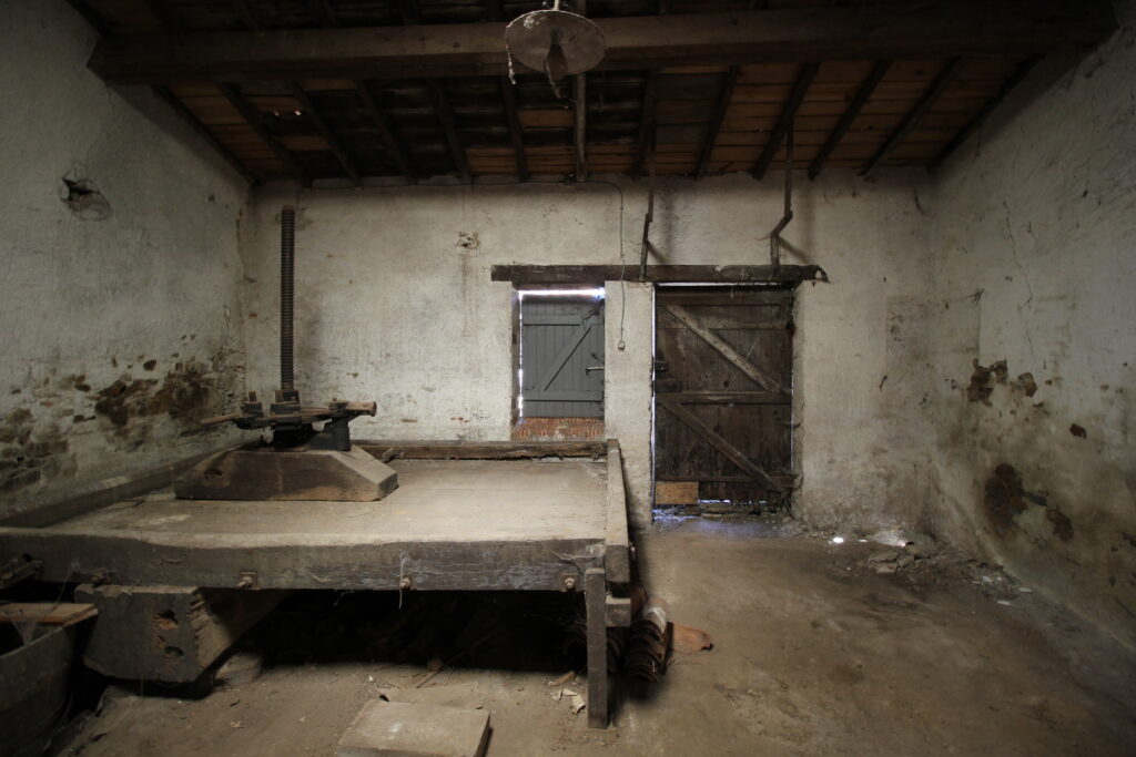 Atelier abandonné avec presse à vis ancienne.
